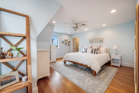 a bedroom with a bed and wooden floor