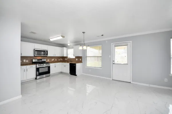 a view of a kitchen with a sink and dishwasher cabinet with a mirror