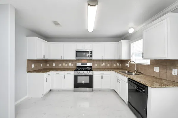 a view of an empty room with wooden floor and a ceiling fan