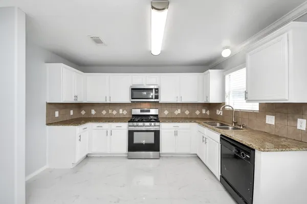 a kitchen with stainless steel appliances granite countertop a stove sink and cabinets