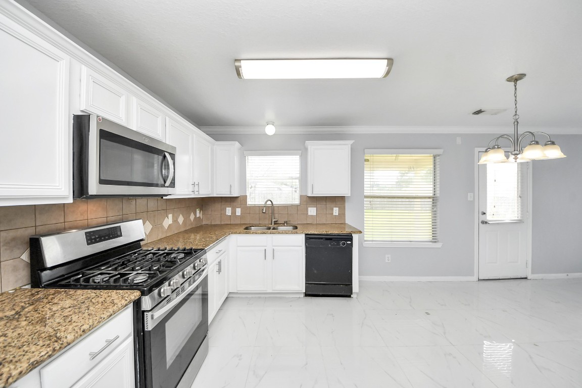 2406 Gwenfair Drive Spring, TX 77373 - Photo 17 of 44 a kitchen with a stove and a microwave