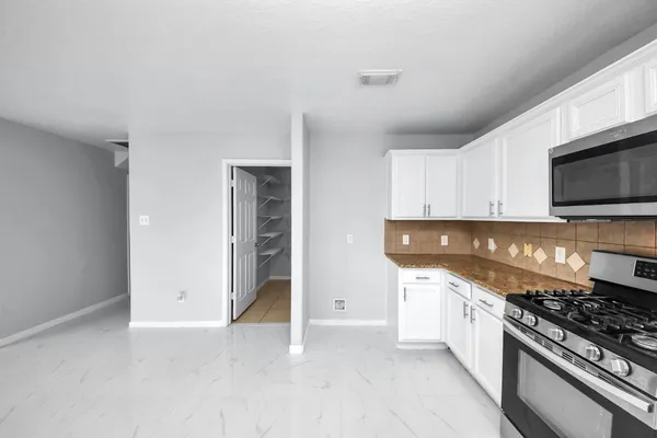a kitchen with granite countertop a stove and a sink