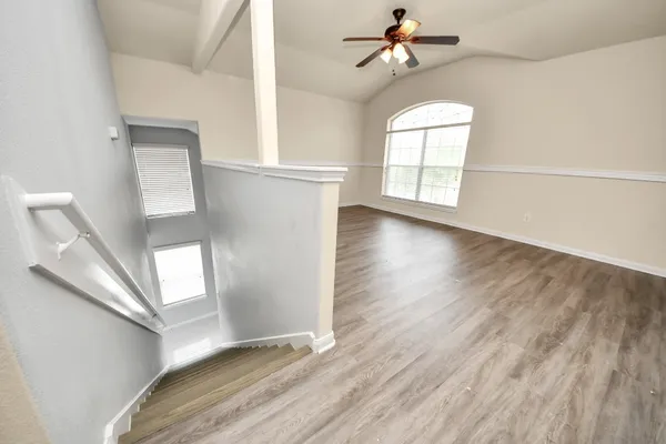 wooden floor in an empty room with a window