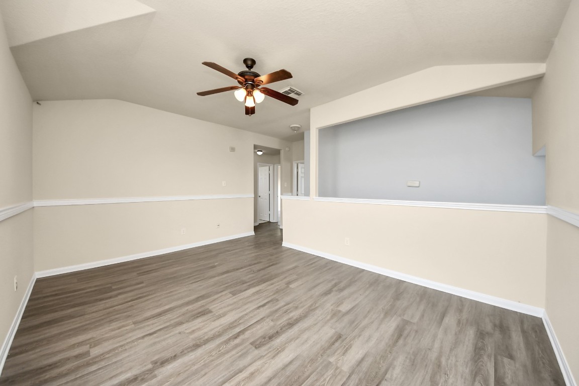 2406 Gwenfair Drive Spring, TX 77373 - Photo 24 of 44 a view of an empty room with wooden floor and a ceiling fan