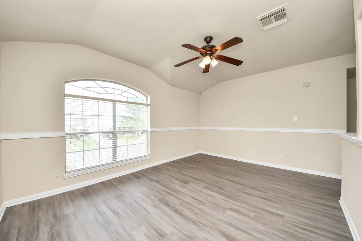 2406 Gwenfair Drive Spring, TX 77373 - Photo 25 of 44 an empty room with wooden floor fan and windows