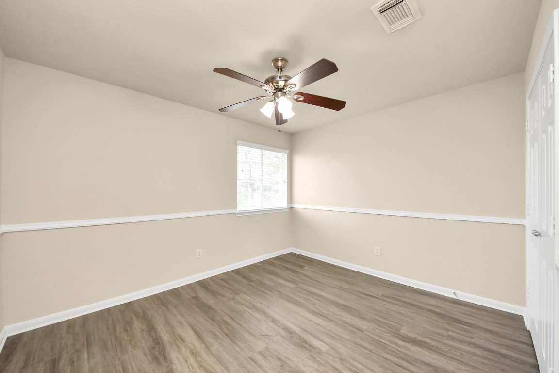 2406 Gwenfair Drive Spring, TX 77373 - Photo 26 of 44 an empty room with wooden floor and windows