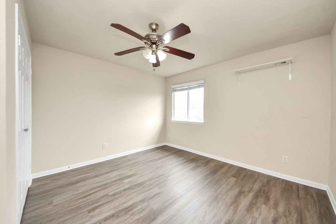 2406 Gwenfair Drive Spring, TX 77373 - Photo 28 of 44 an empty room with wooden floor fan and windows