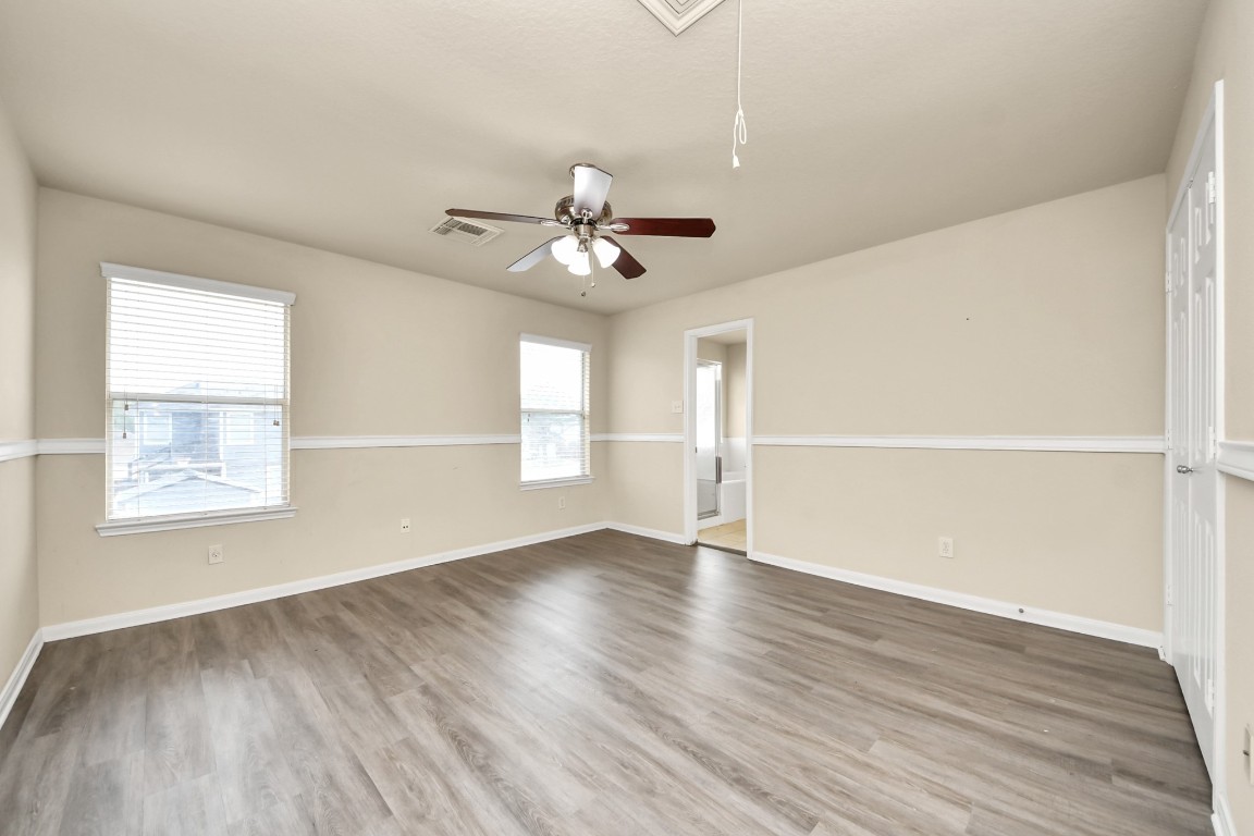 2406 Gwenfair Drive Spring, TX 77373 - Photo 31 of 44 an empty room with wooden floor chandelier fan and windows