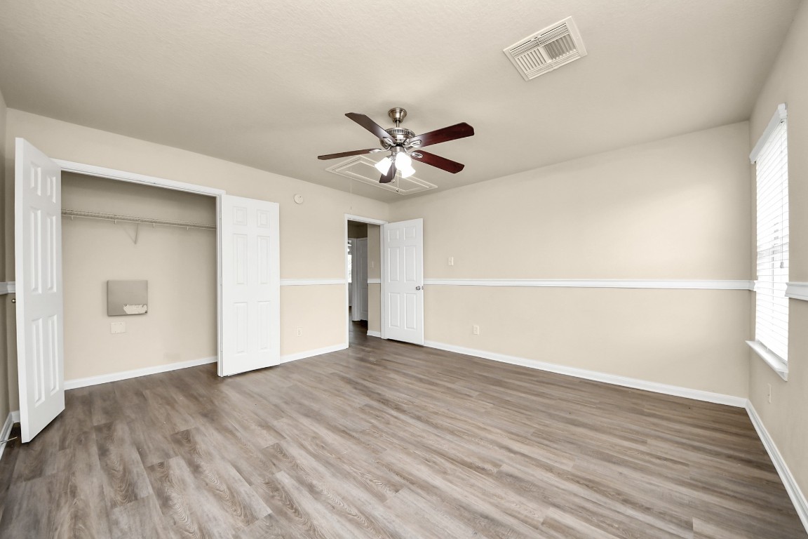 2406 Gwenfair Drive Spring, TX 77373 - Photo 36 of 44 an empty room with wooden floor and a ceiling fan
