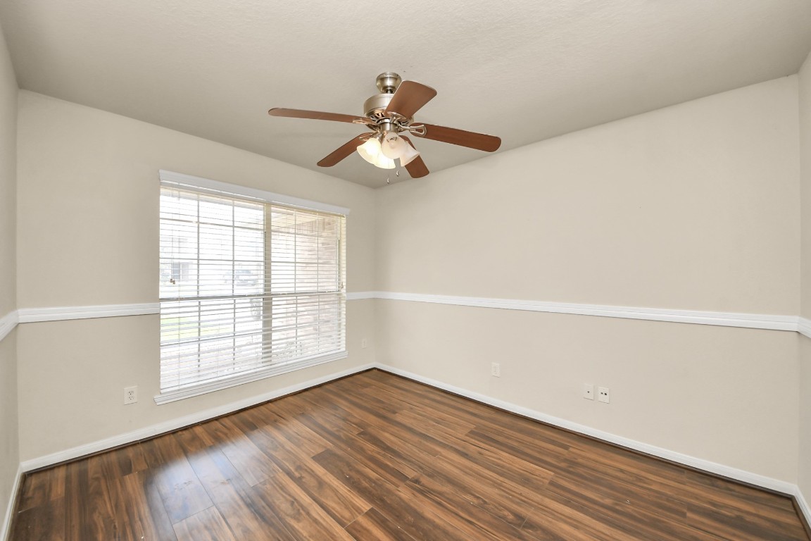2406 Gwenfair Drive Spring, TX 77373 - Photo 6 of 44 an empty room with wooden floor fan and windows