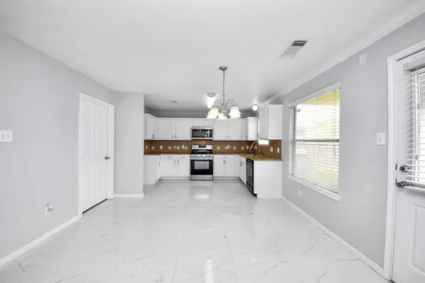 a view of a kitchen with granite countertop stainless steel appliances and a large window