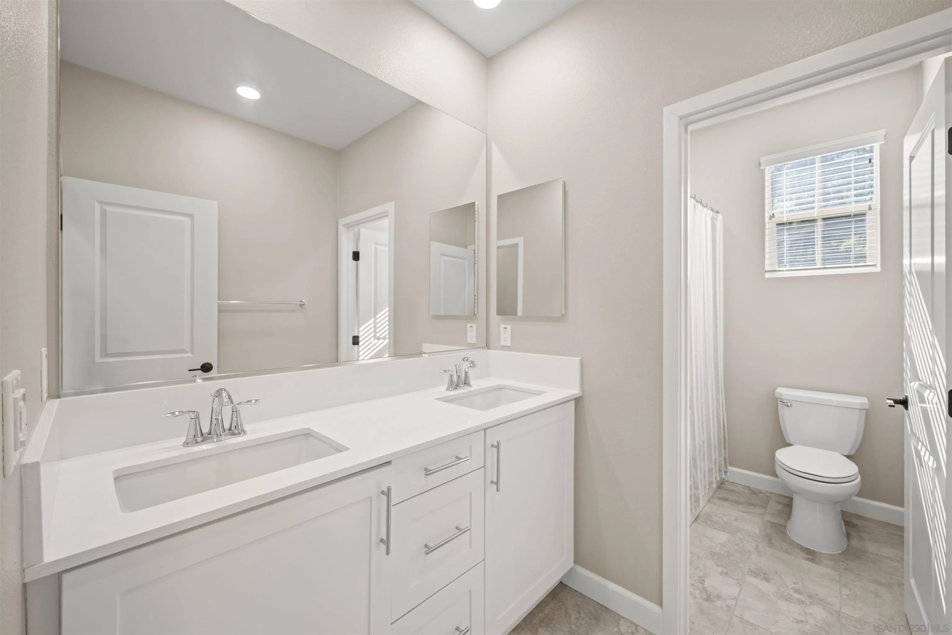 1151 Delpy View Point Vista, CA 92084 - Photo 25 of 44 a spacious bathroom with a double vanity sink a mirror and a toilet
