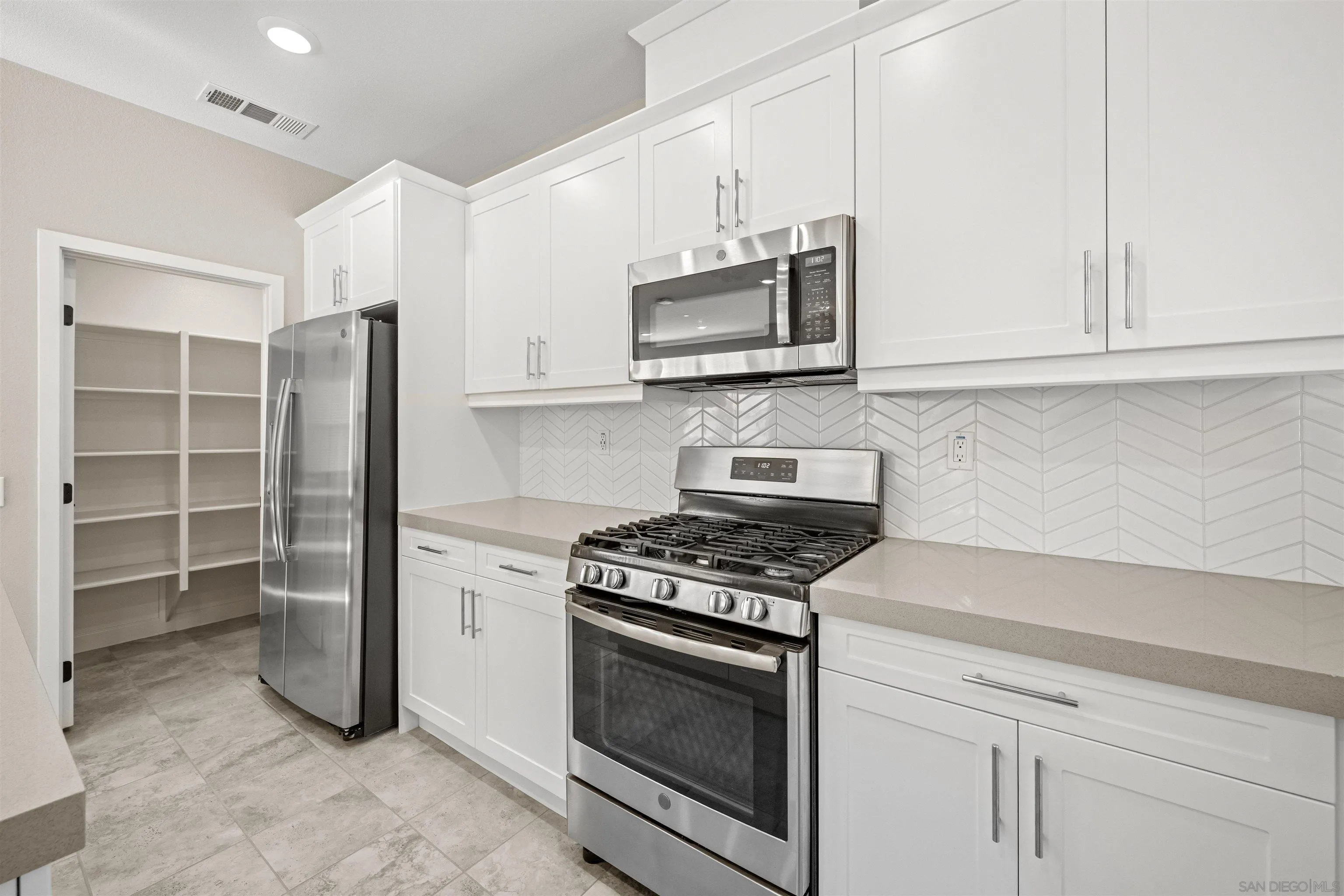 1151 Delpy View Point Vista, CA 92084 - Photo 7 of 44 a kitchen with stainless steel appliances granite countertop a stove and a refrigerator