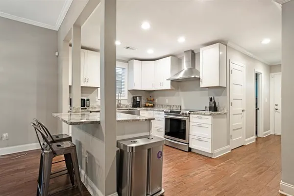 a kitchen with kitchen island granite countertop wooden floors and white stainless steel appliances