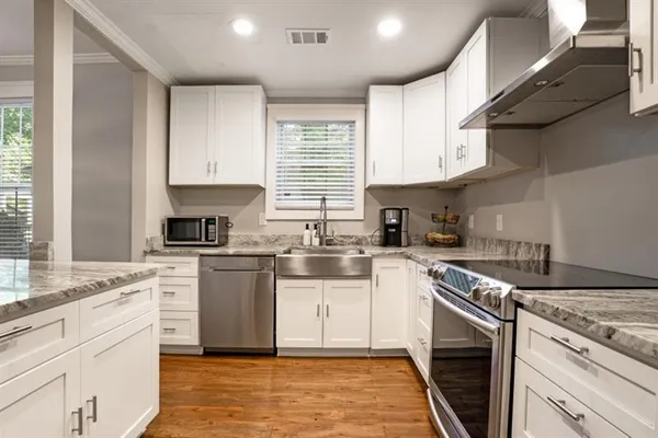 a kitchen with cabinets appliances a sink and a window