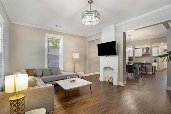a living room with furniture flat screen tv and wooden floor