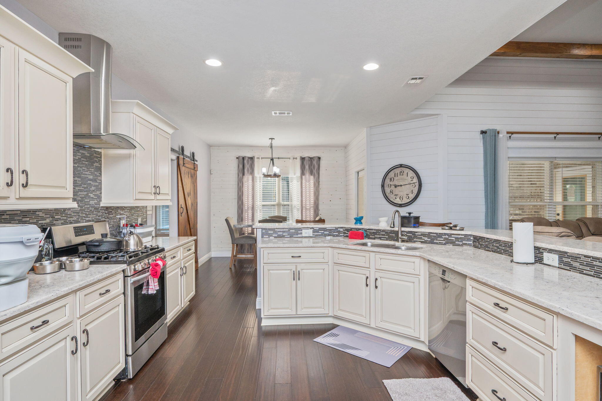 5777 Wildwood Road Crestview, FL 32536 - Photo 15 of 68 a kitchen with a sink dishwasher a stove and white cabinets with wooden floor