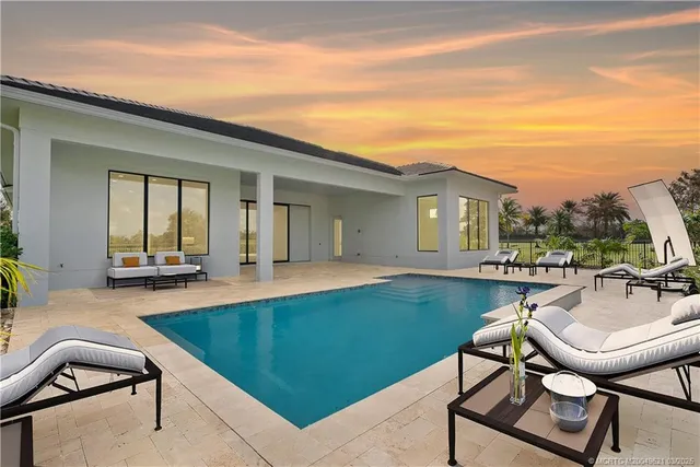 a view of a house with swimming pool and sitting area