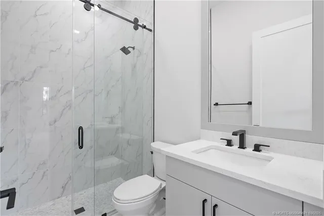 a kitchen with stainless steel appliances a sink a stove and white cabinets