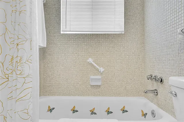 a bathroom with a bathtub and a shower curtain