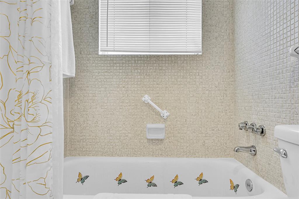 330 South Cypress Road, Unit 610 Pompano Beach, FL 33060 - Photo 12 of 35 a bathroom with a bathtub and a shower curtain