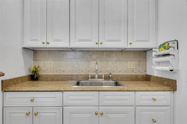 a kitchen with granite countertop white cabinets and a white stainless steel appliances