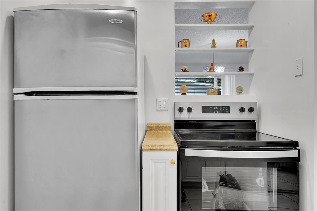 330 South Cypress Road, Unit 610 Pompano Beach, FL 33060 - Photo 7 of 35 a kitchen with a stove and white cabinets