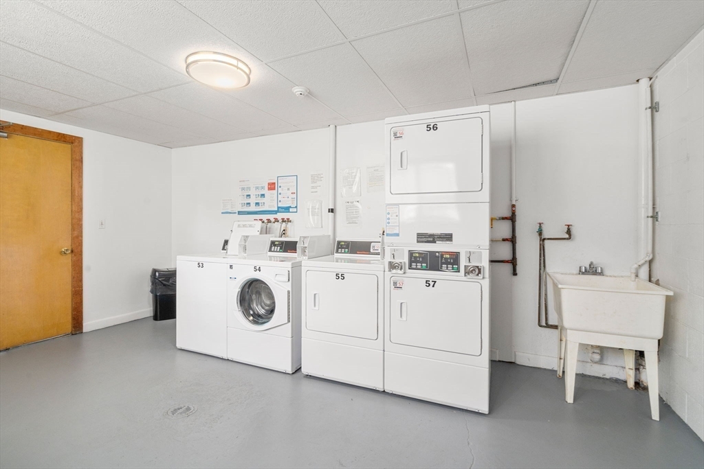 64 Jacqueline Road, Unit 11 Waltham, MA 02452 - Photo 9 of 17 a view of kitchen with white cabinets stainless steel appliances and wooden floor