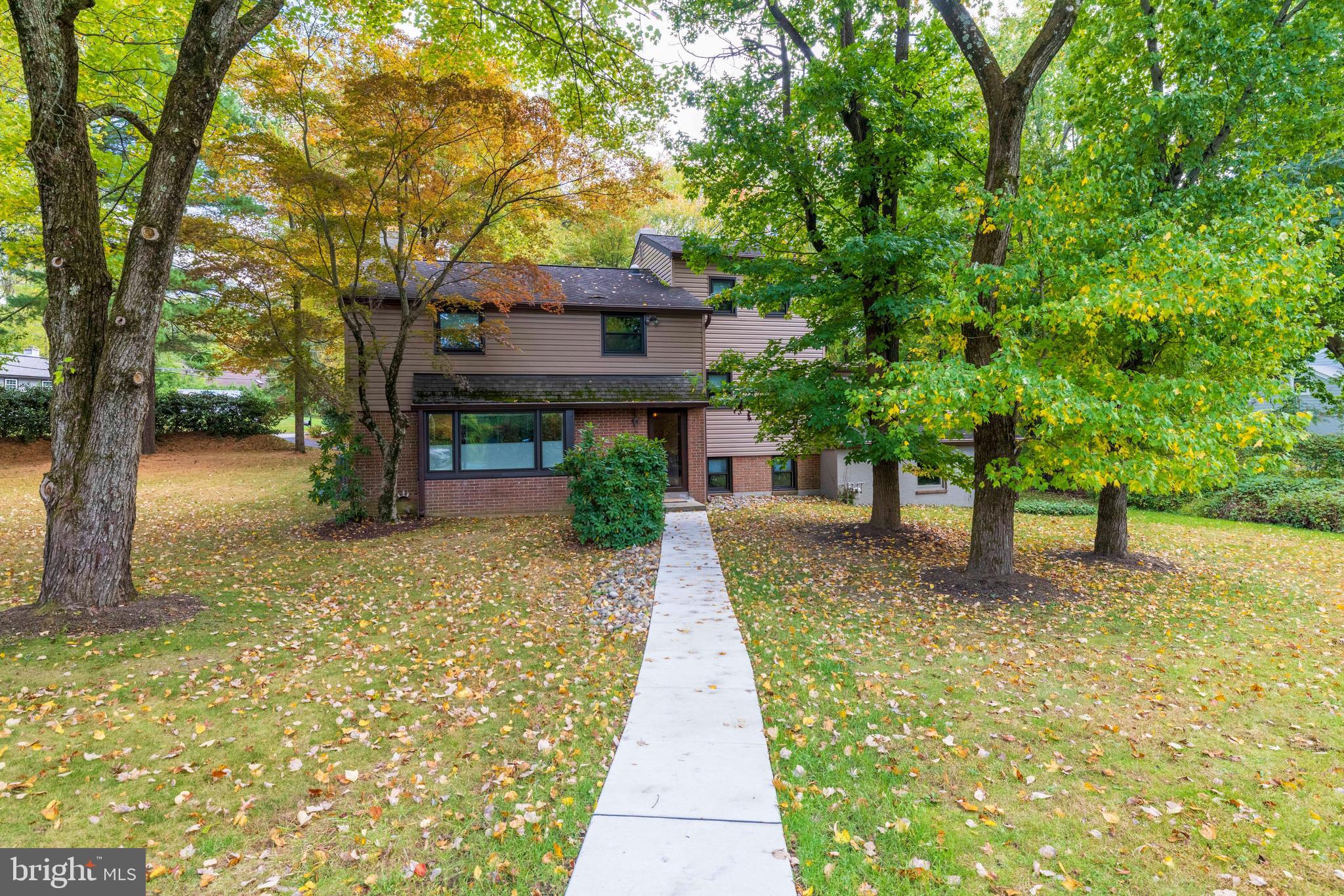 a front view of a house with a yard and trees