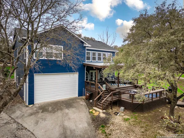 a view of a house with pool chairs and a fire pit