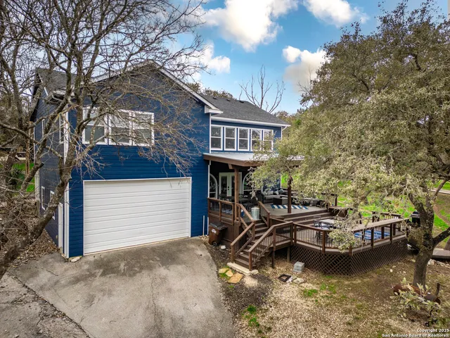 a view of a house with pool chairs and a fire pit