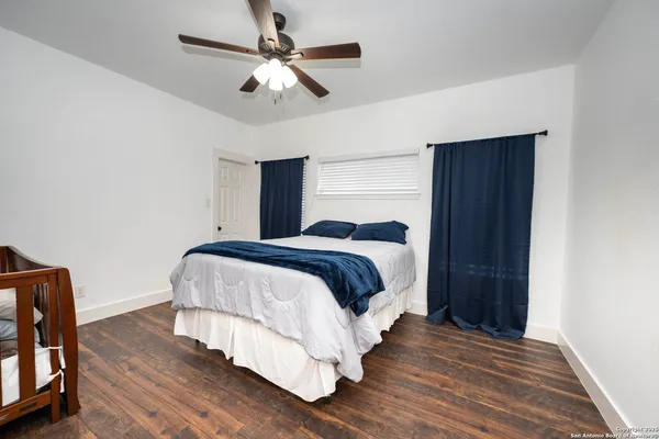a bedroom with a bed chandelier and a window
