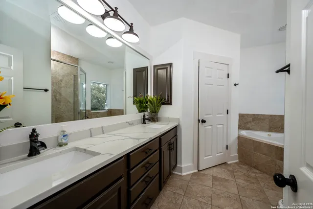 a spacious bathroom with a granite countertop sink a mirror and a shower