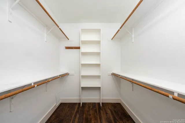 a view of walk in closet with empty racks