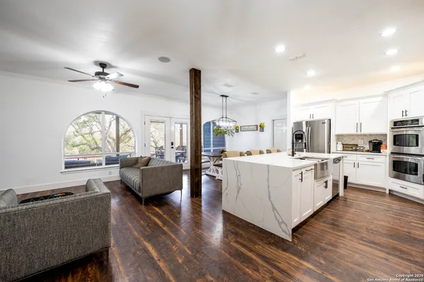 a living room with kitchen island furniture and a chandelier