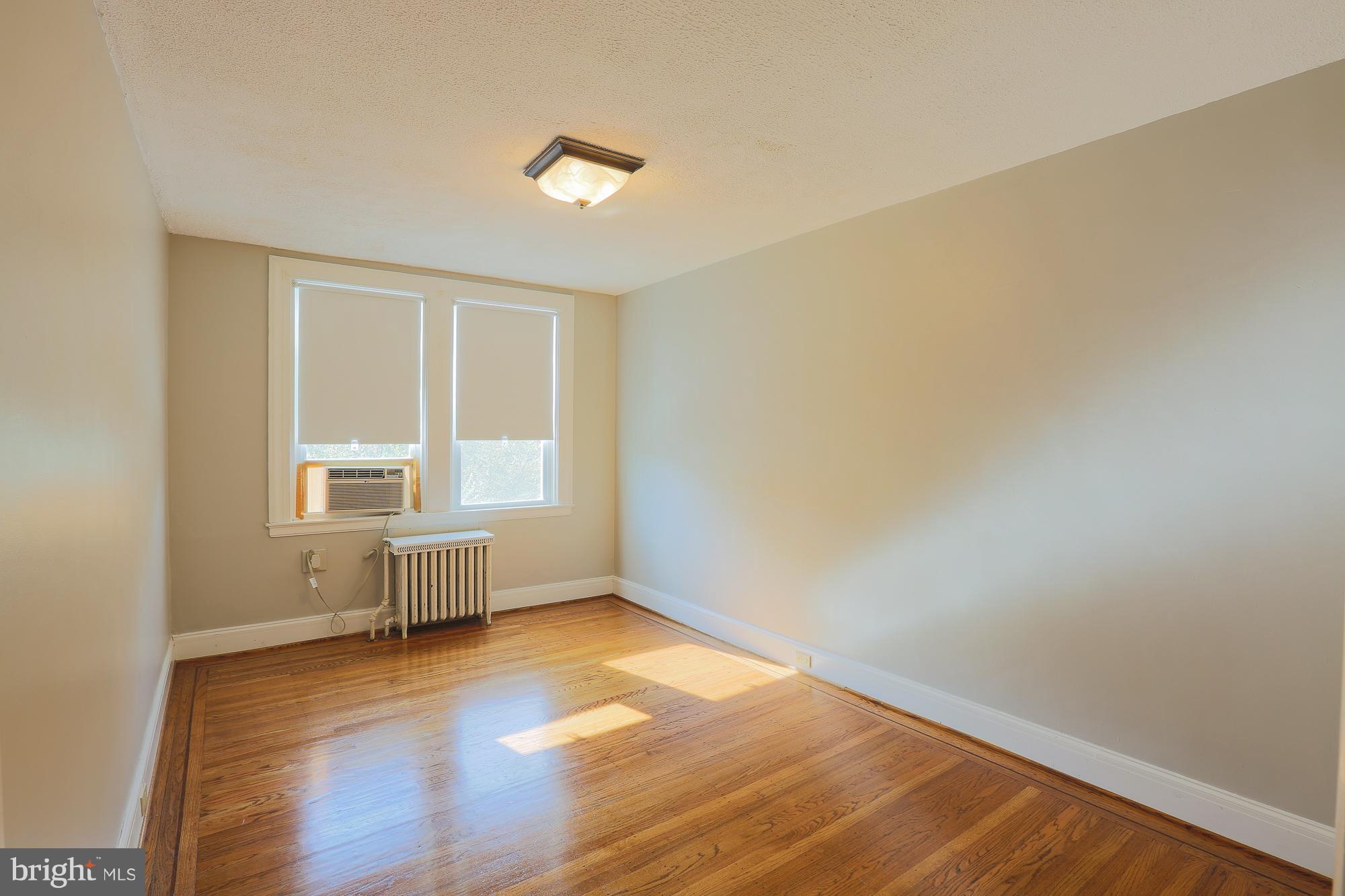 3628 Rexmere Road Baltimore, MD 21218 - Photo 21 of 28 a view of an empty room with wooden floor and a window