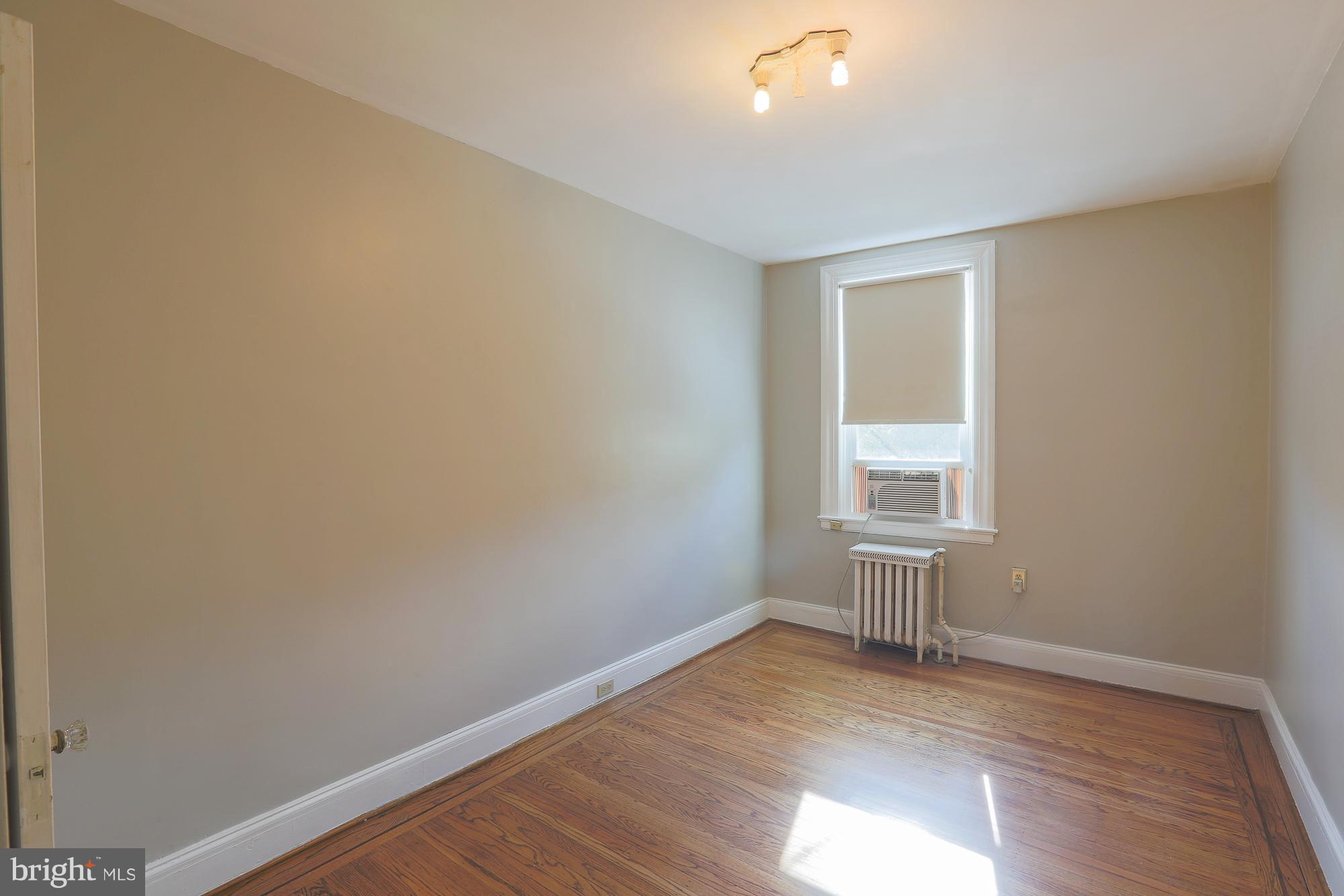 3628 Rexmere Road Baltimore, MD 21218 - Photo 22 of 28 an empty room with wooden floor and windows