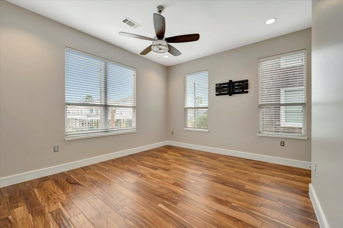 1202 Todville Road Seabrook, TX 77586 - Photo 22 of 45
A serene first-floor bedroom featuring rich hardwood floors, two-inch faux blinds for privacy, and large windows offering breathtaking views of the bay.