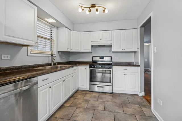 a kitchen with granite countertop white cabinets and white appliances