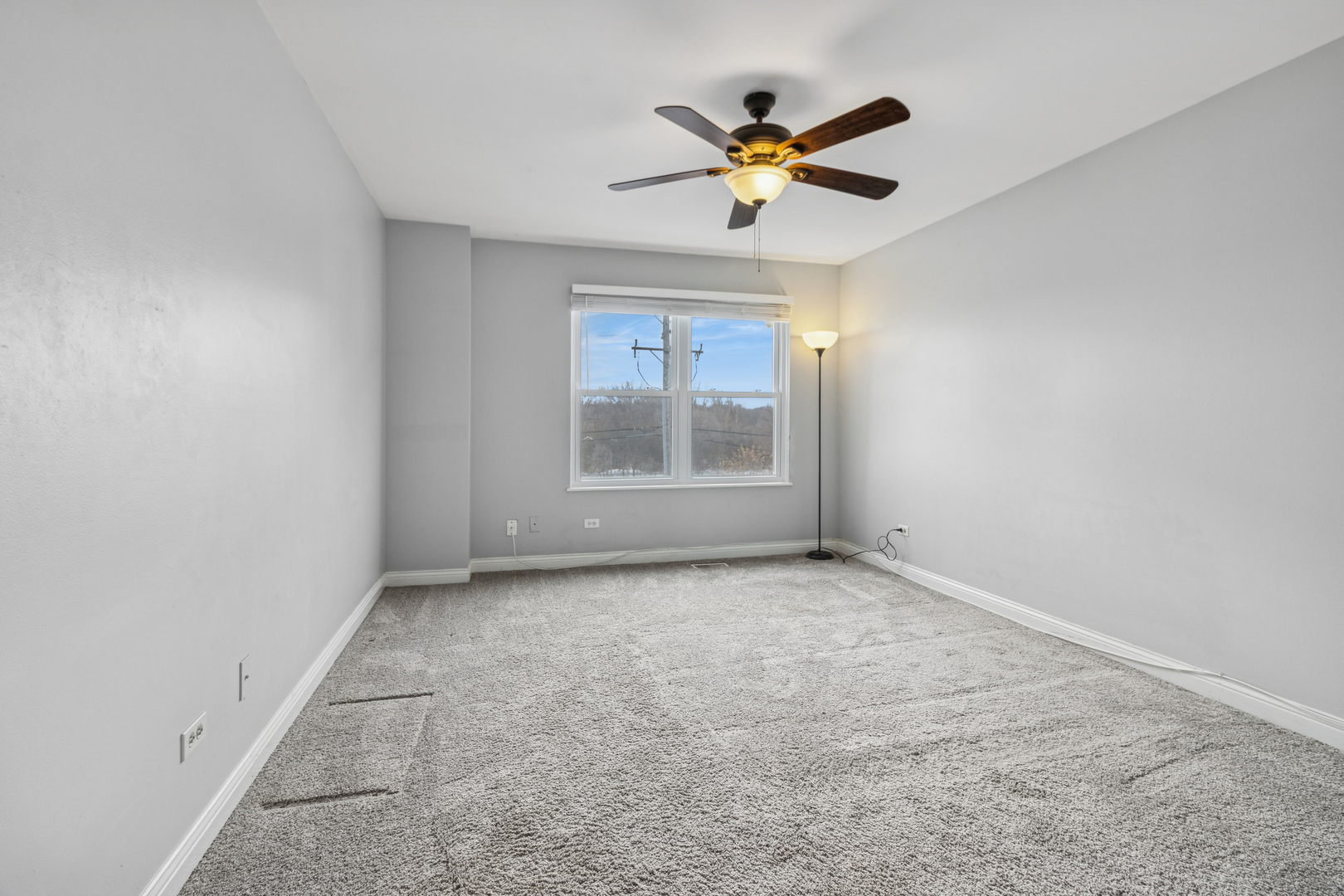 8313 High Point Circle, Unit F Darien, IL 60561 - Photo 15 of 20 an empty room with chandelier fan and windows