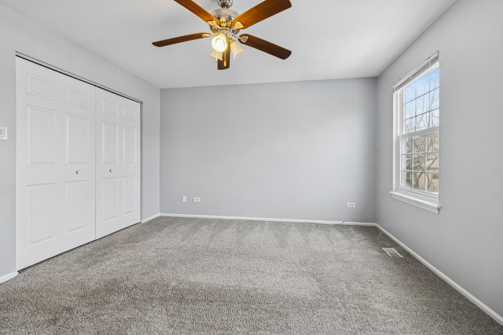8313 High Point Circle, Unit F Darien, IL 60561 - Photo 17 of 20 an empty room with windows and fan