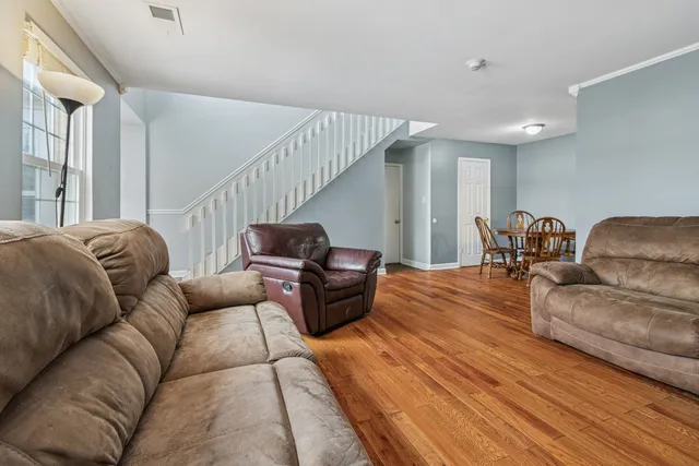 a living room with furniture and wooden floor