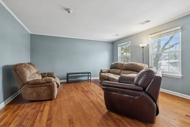 a living room with furniture window and wooden floor
