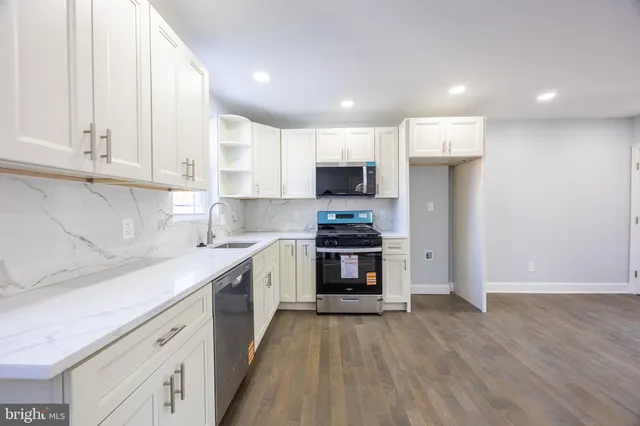 a kitchen with kitchen island granite countertop a stove a sink and a refrigerator