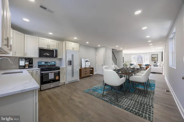 a living room with furniture a flat screen tv and kitchen view