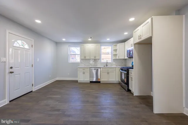 a kitchen with a refrigerator and white cabinets
