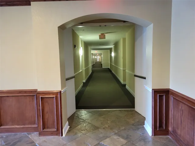 a view of a hallway with wooden floor and stairs