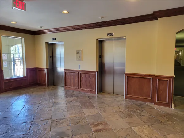 a view of a hallway with wooden cabinets