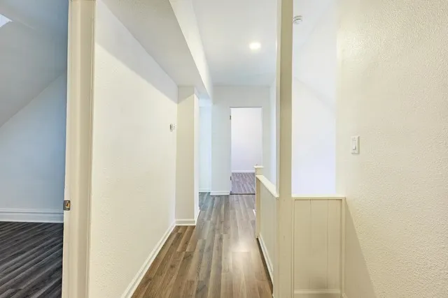 a view of a room with wooden floor and a bathroom