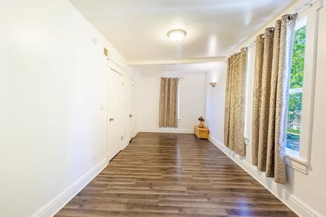 a view of a hallway with wooden floor and staircase